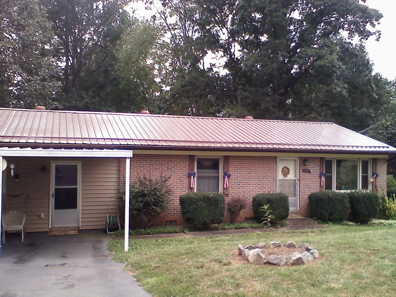 Bronze metal roof and carport on a brick ranch home — Roof Repair work by our crew in Sheffield